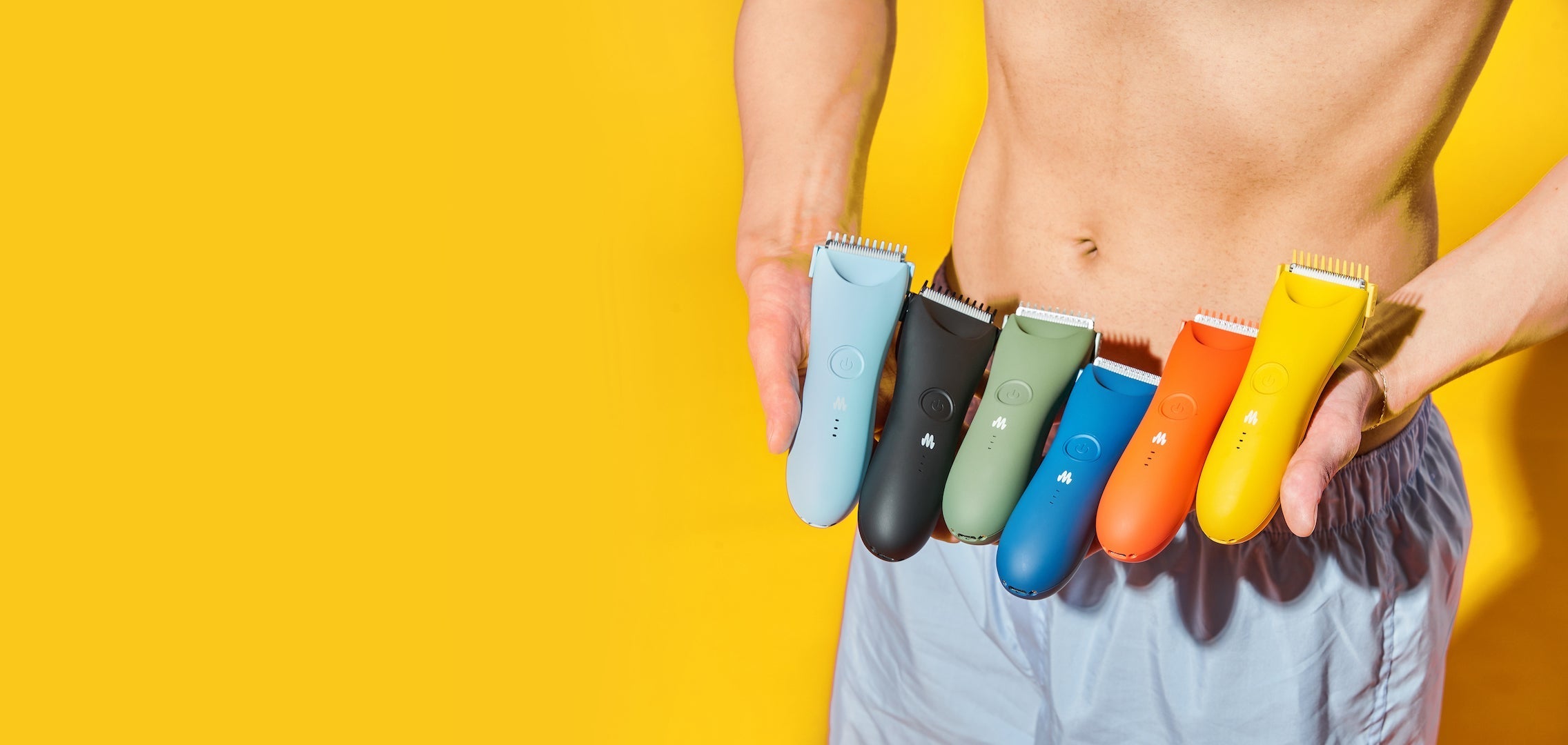 Man holding trimmers of 6 different colors